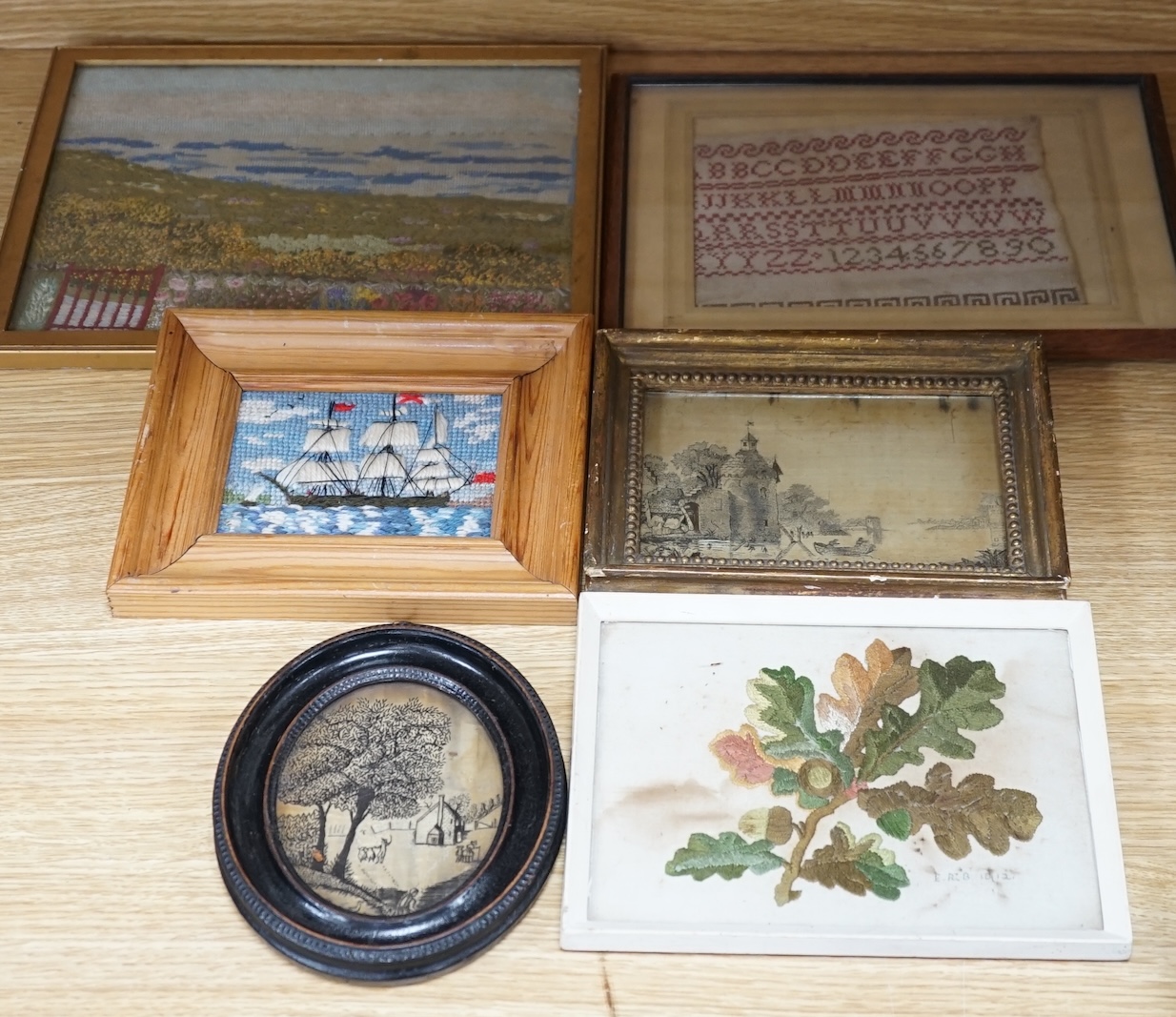 From the Studio of Fred Cuming. Six needlework embroideries including an alphabet sampler, Study of oak leaves, and 19th century landscapes, largest 23 x 29. Condition - varies, poor to fair